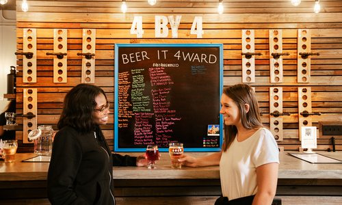 Two women at the bar drinking beer at 4 By 4 Brewing Company