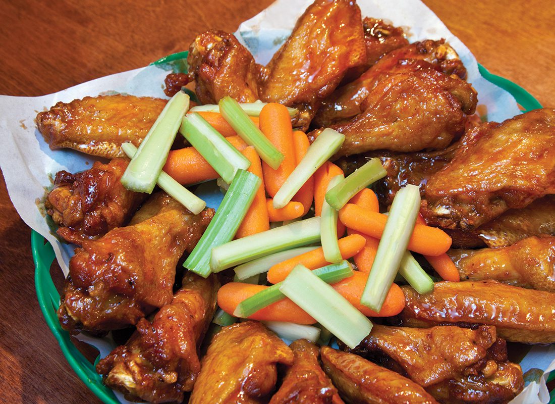 buffalo chicken wings in a basket with carrots and celery