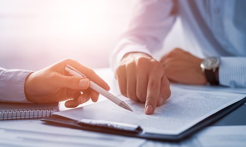 Hand of an attorney helping a client go over paperwork