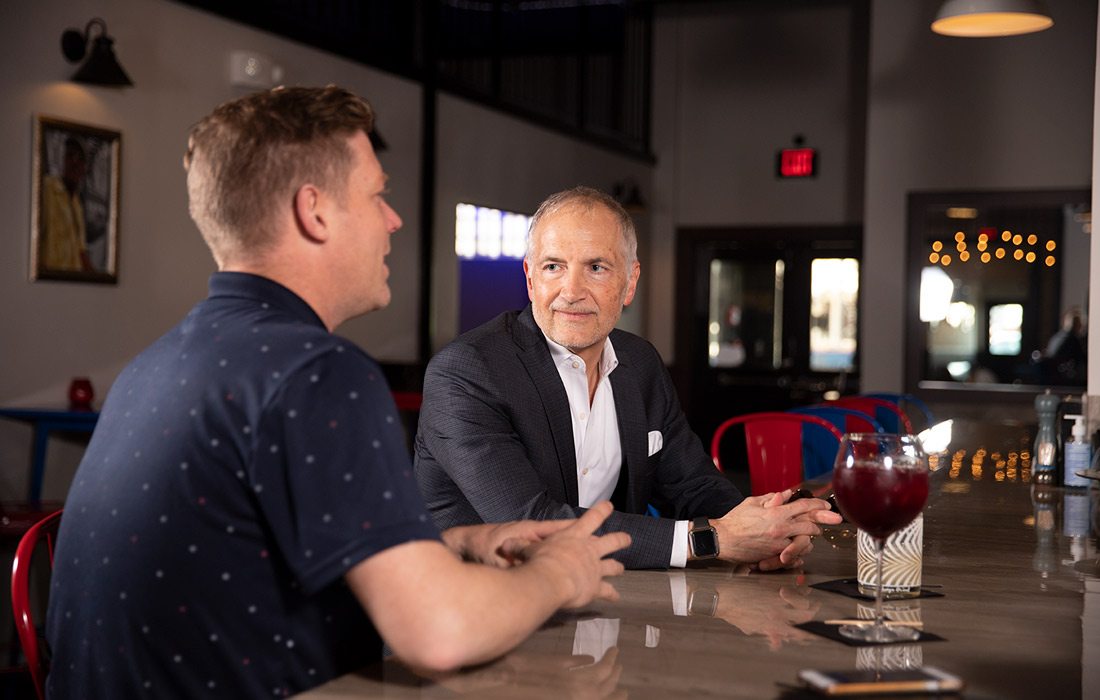 Two men sitting at bar