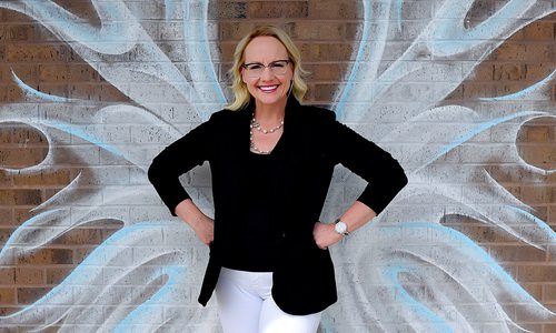 Carrie Arquitt of Arquitt Pediatric Dentistry in front of a mural by Andrea Ehrhardt in Springfield MO