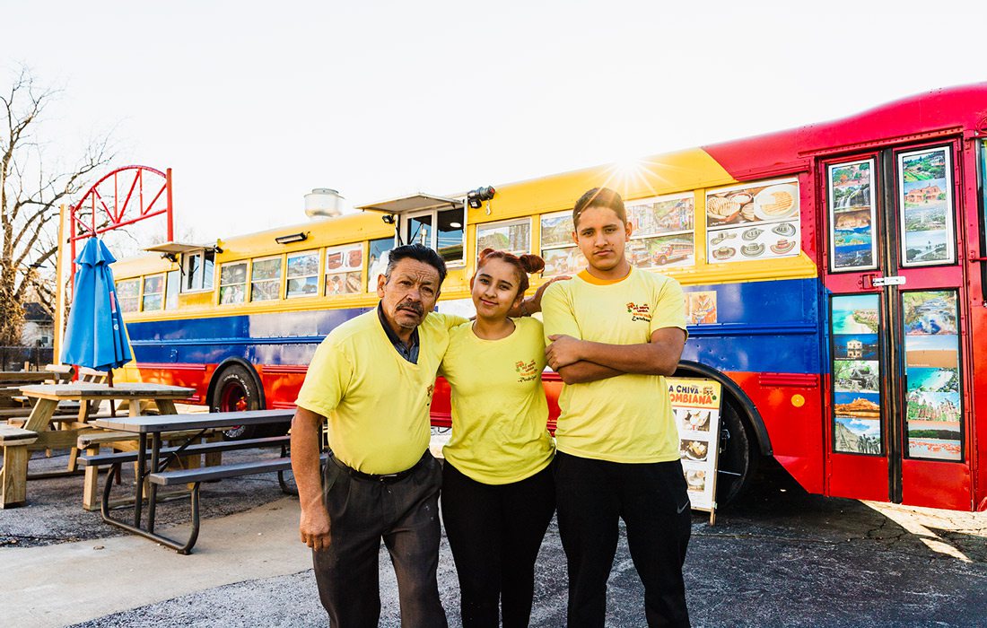 Siblings and grandfather in front of bus