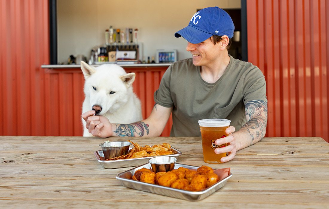 Man feeds dog at the Bark Yard in Springfield MO