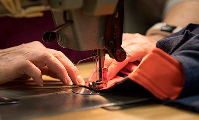 Close up image of hands on a sewing machine.