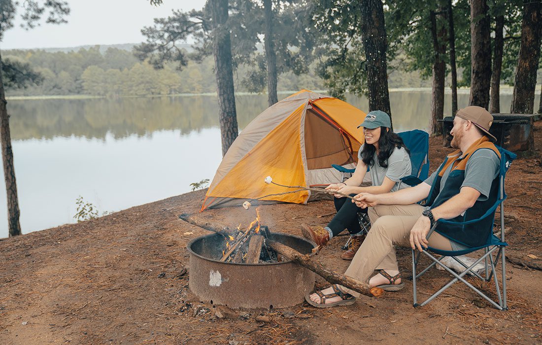 Young couple roasting marshmallows over a fire at Mount Magazine State Park