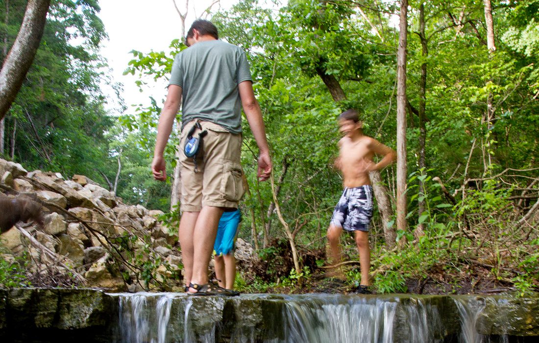 Father and sons catching crawdads in Missouri