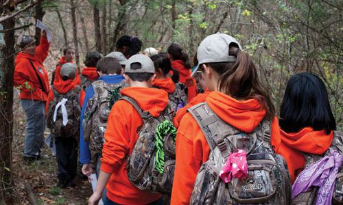 kids walking in woods with backpacks