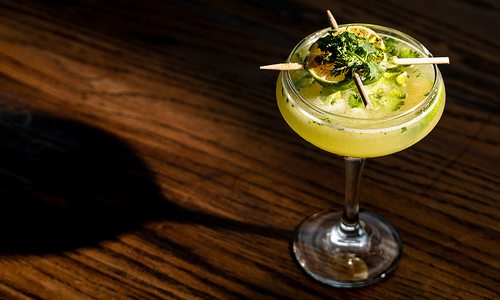 Pineapple and Cilantro gimlet on brown tabletop