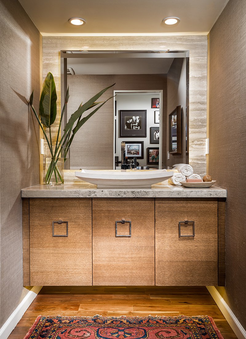 Powder bath with wood cabinets and grass-cloth wallpaper by Nathan Taylor.