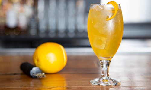 yellow cocktail in a glass with a lemon