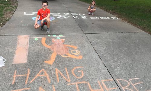 Ryland Matthews and Elise Matthews chalk messages in Emerald Park