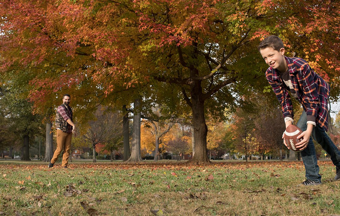 father and son playing football