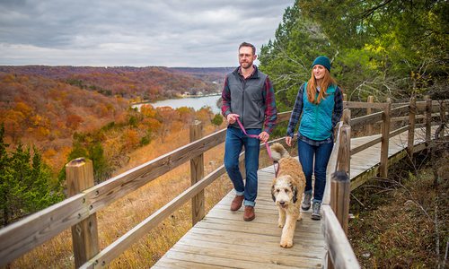 Young couple and their dog on a fall hike in Ha Ha Tonka in Camdenton, Missouri