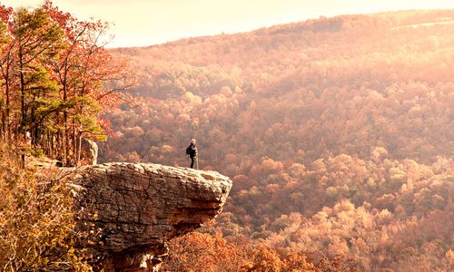 Man on a rock ledge along Hawksbill Crag in Arkansas