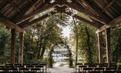 An outdoor wedding chapel overlooks the Finley River, the Riverside Bridge and rushing waterfalls.