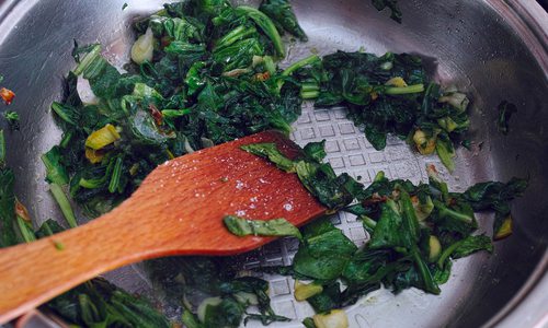 Fried spinach cooking in a pan.