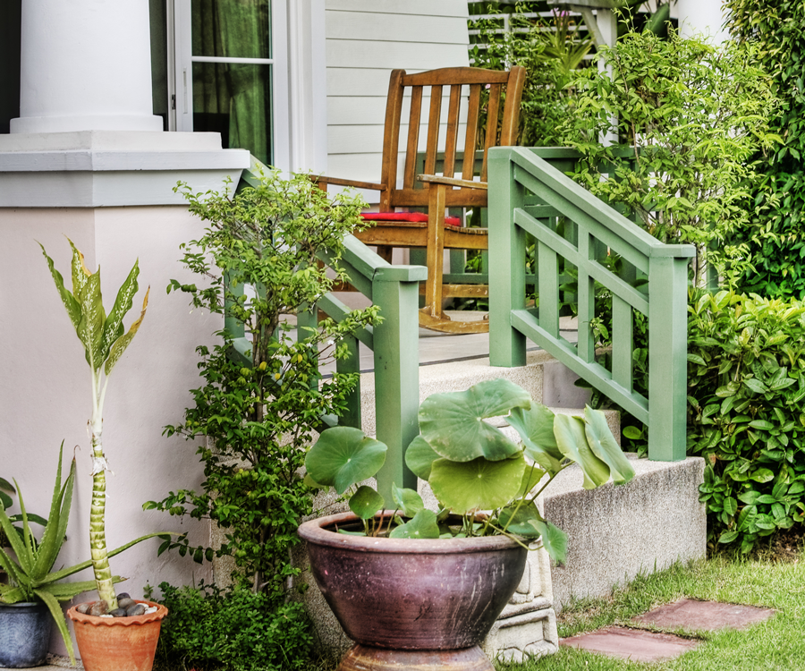 Front porch full of pots and planters with vegetables