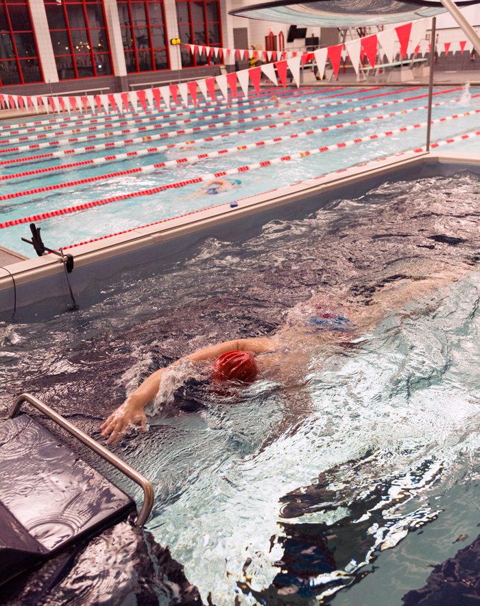 person swimming in an endless pool