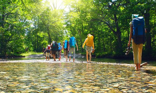 Hikers crossing a shallow river