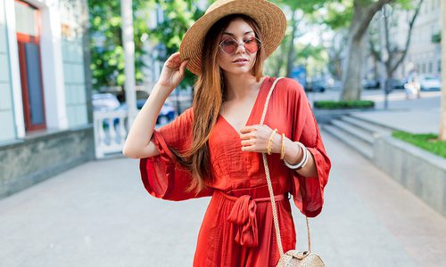 Young woman wearing a red jumpsuit and a straw hat