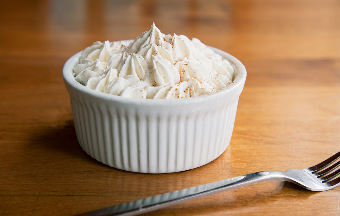 Coconut Tres Leches in white dish next to fork