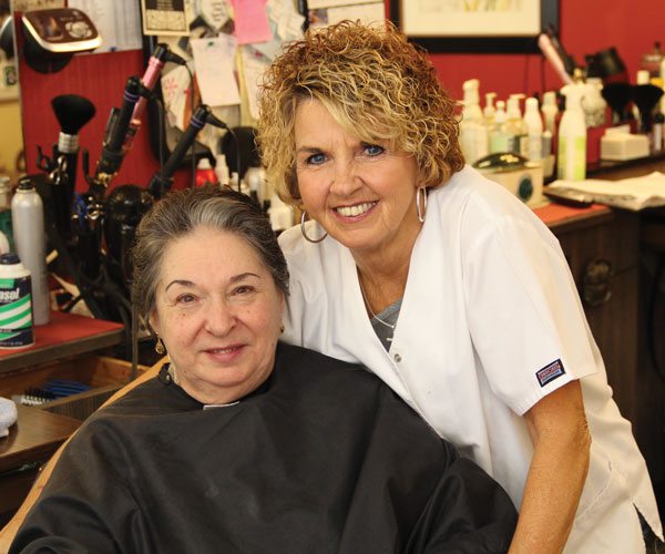 Sonja leans into her client as they both smile at the camera