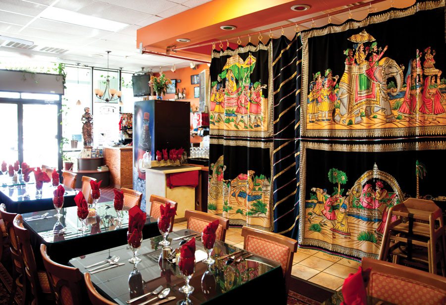 Indian restaurant with decorative curtains and table settings