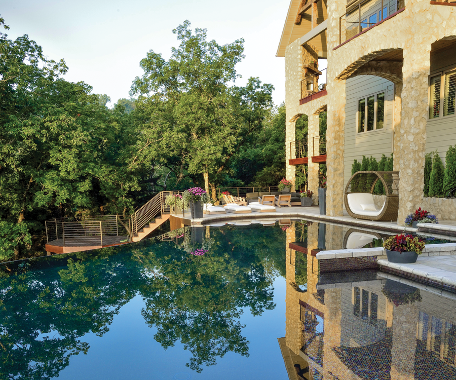 From the pool house dining room, guests have a lovely view of the pool and backside of the Lemley’s multi-story residence.