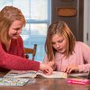 Woman tutoring a young girl