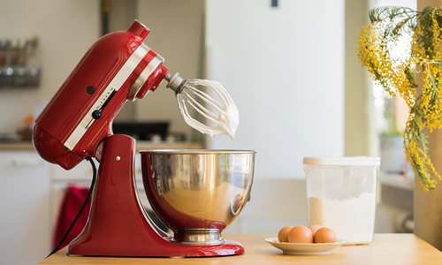 Red KitchenAid stand mixer in a bright white kitchen