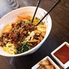 Bibimbap served with meat, veggies and sauce.