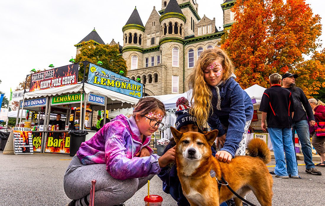 Two girls with a dog at the Maple Leaf Festival