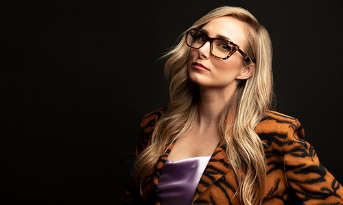 Woman wearing a tiger stripe jacket and tortious shell glasses