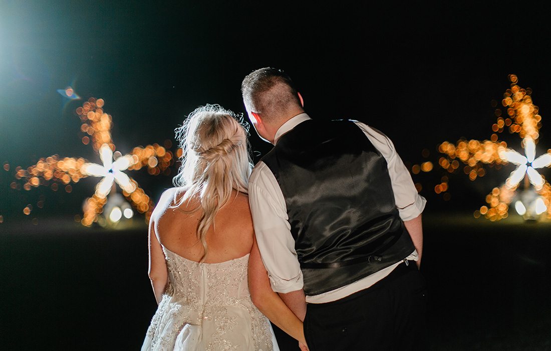 Couple looking on to an Opulence firework show.