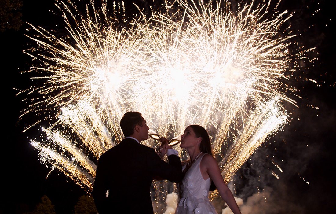 Bride and groom celebrating with fireworks after their wedding.