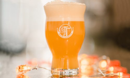 Pint of beer surrounded by lights at Tie & Timber Beer Co