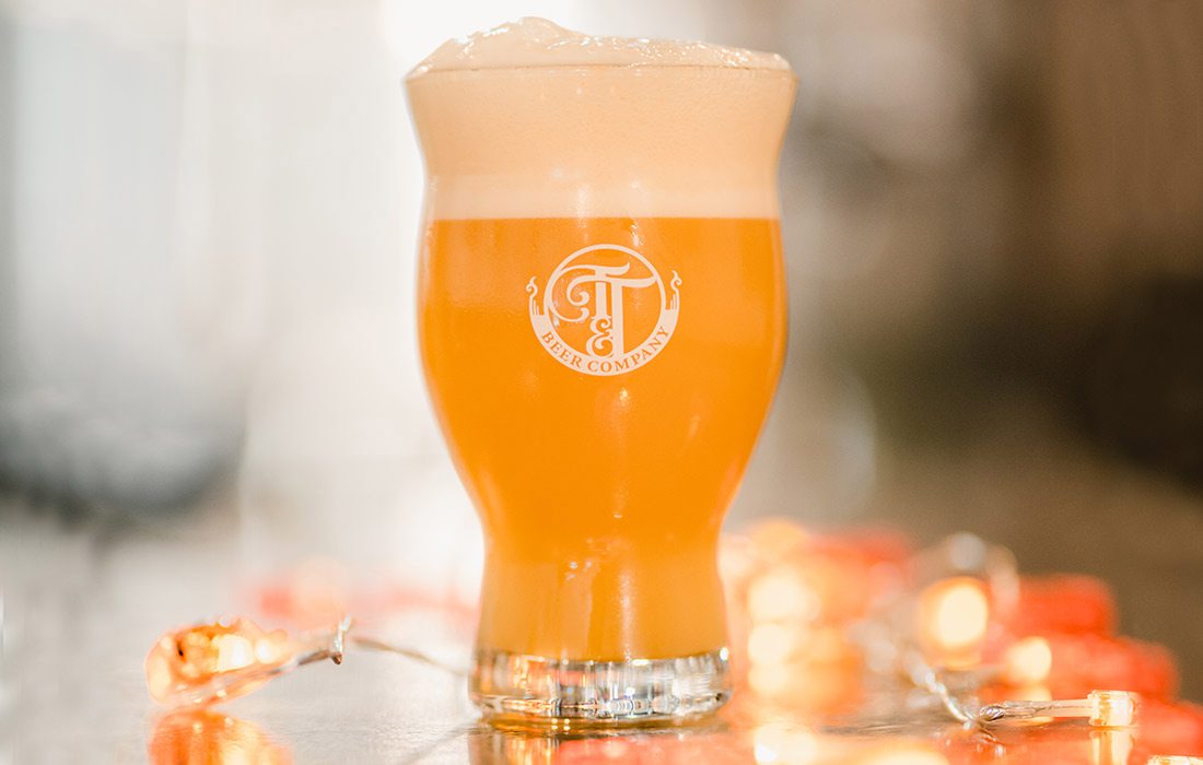 Pint of beer surrounded by lights at Tie & Timber Beer Co