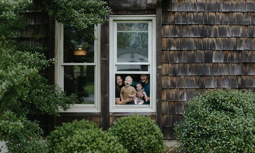 Olivia Jahnke and her family through a window at home