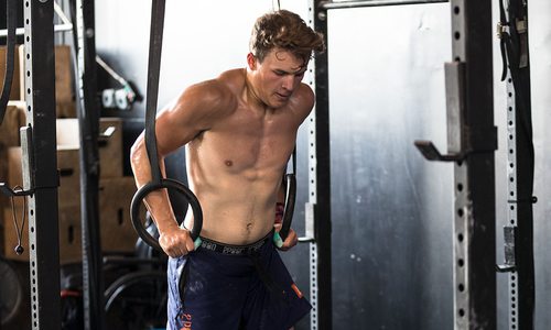 Nathan practices on the rings at the gym