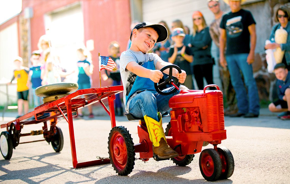 Kid on small tractor at fall festival