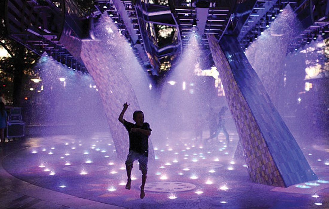 child in water fountain