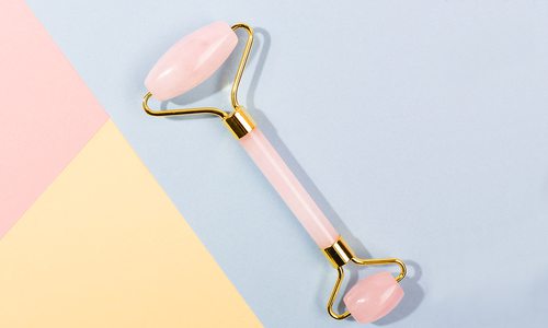 Jade facial roller with lit candle.