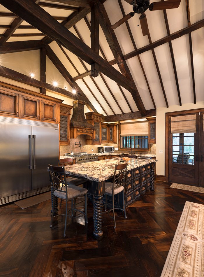 Tudor kitchen with island and vaulted wood ceilings.