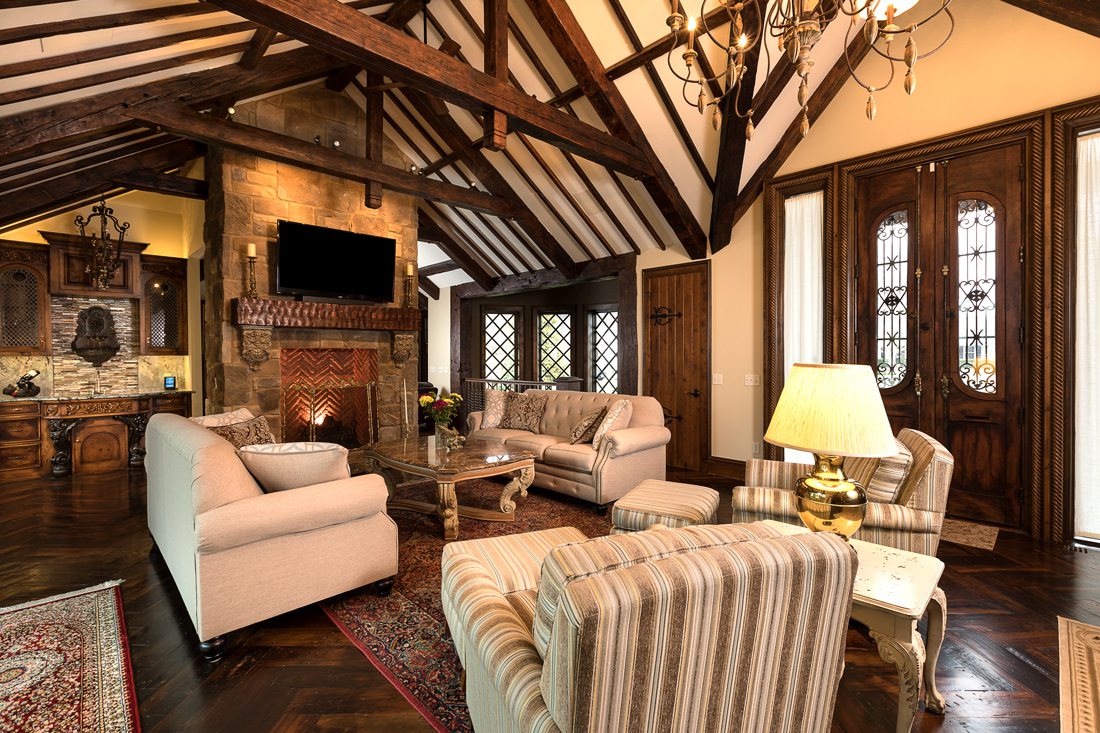 Tudor living room in Harry Potter home with wood beam ceiling, French door, chandelier.