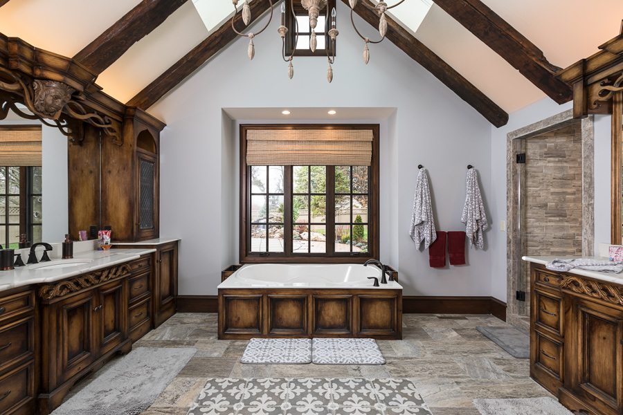 Tudor style master bath with skylights and wooden fixtures.