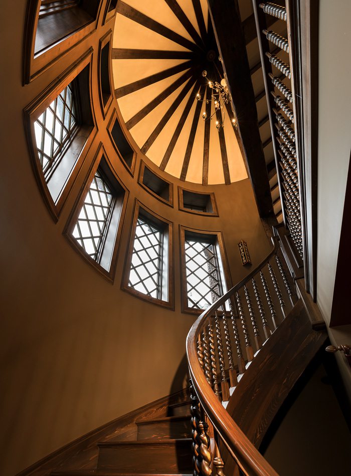 Tudor floating wood staircase with vaulted ceilings.