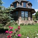 Slider Thumbnail: Tudor style home tower with windows and landscaping.