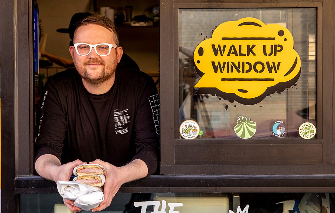 man handing sandwich out window