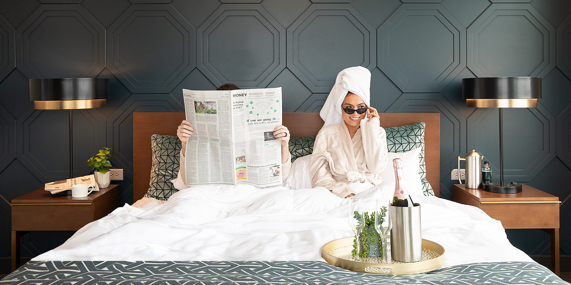 Couple lounging in bed at Hotel Vandivort in Springfield, MO