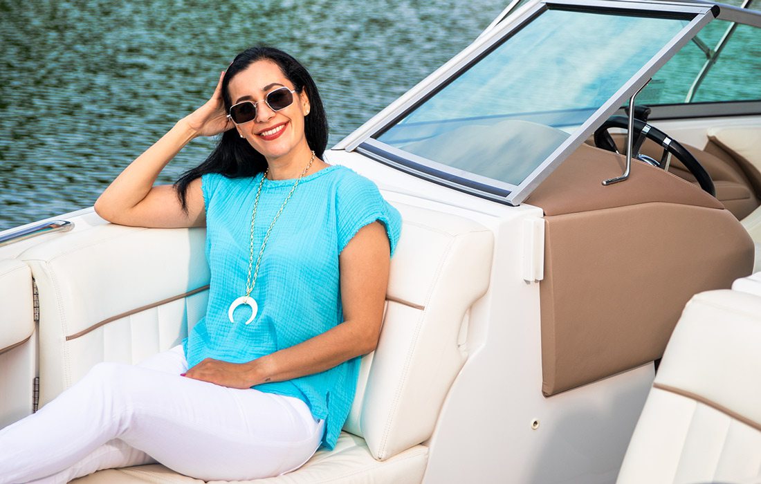 Summer style model sitting in boat on the lake